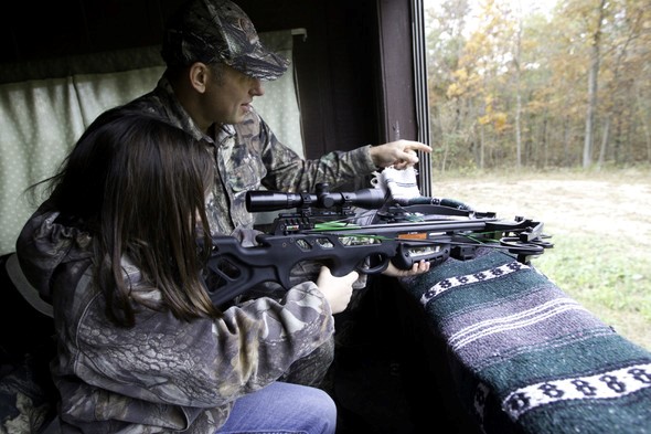 A father and daughter use a crossbow