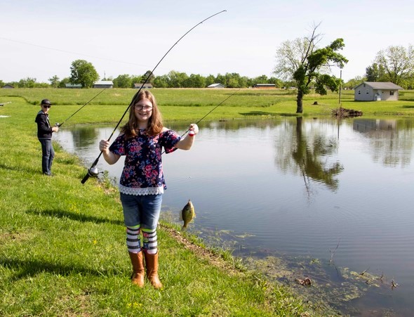 Young girl shows off fish caught on pole-and-line