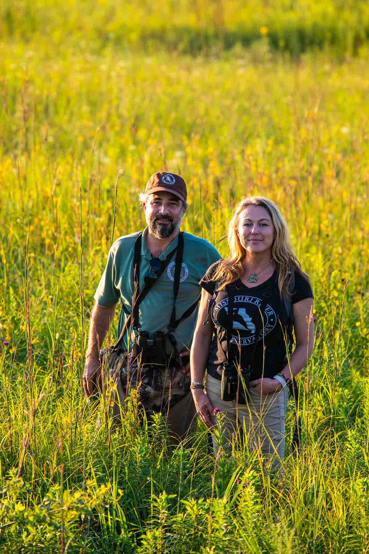 Man and woman standing in a field of tall grass