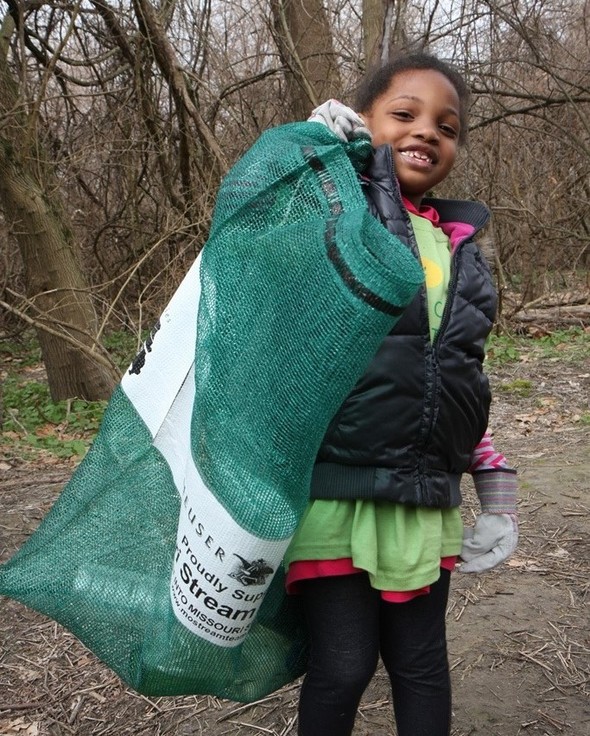 Girl with sack of trash from a clean-up.