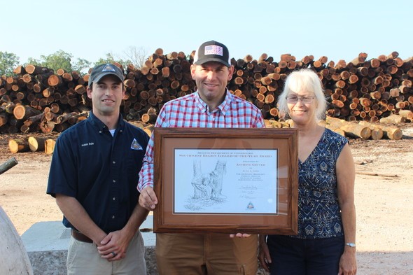 Anthony Gruver holds his MDC Southwest Regional Logger of the Year Award.