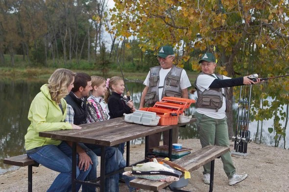 Two instructors teach a family how to fish