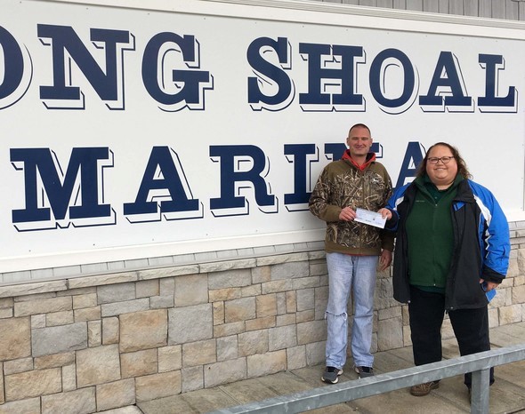 Laura Ruman presents Mike Eckers with a cost-share grant check for upgrades to a pump station at Long Shoal Marina.