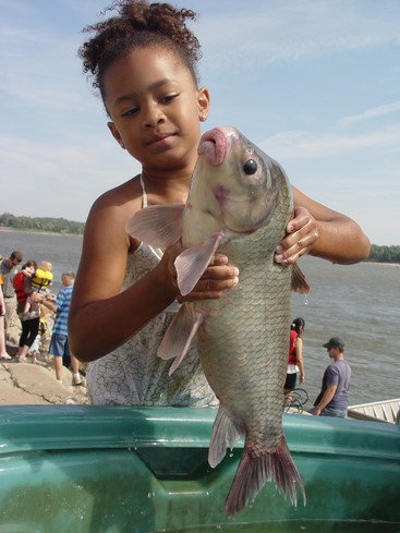 Little girl holding a fish.