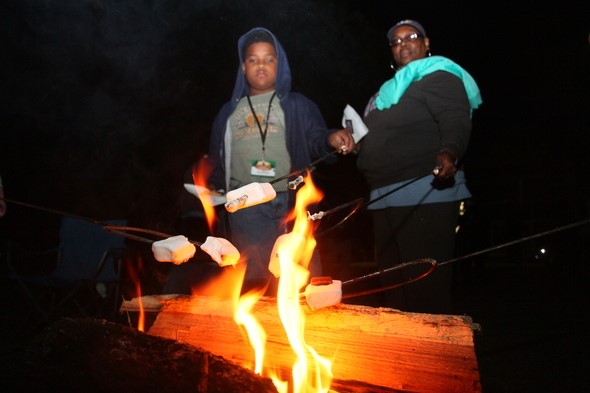 Two people making smores by the camp fire.