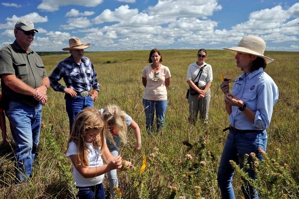 A guide speaks with participants during a tour of Wah'Kon-Tah Prairie