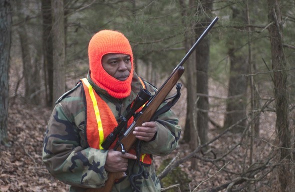 Deer hunter in woods with rifle