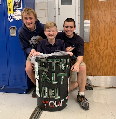 students posing with winning trashcan