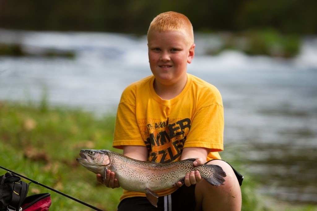 A young angler shows off his trout at Maramec Spring Park.