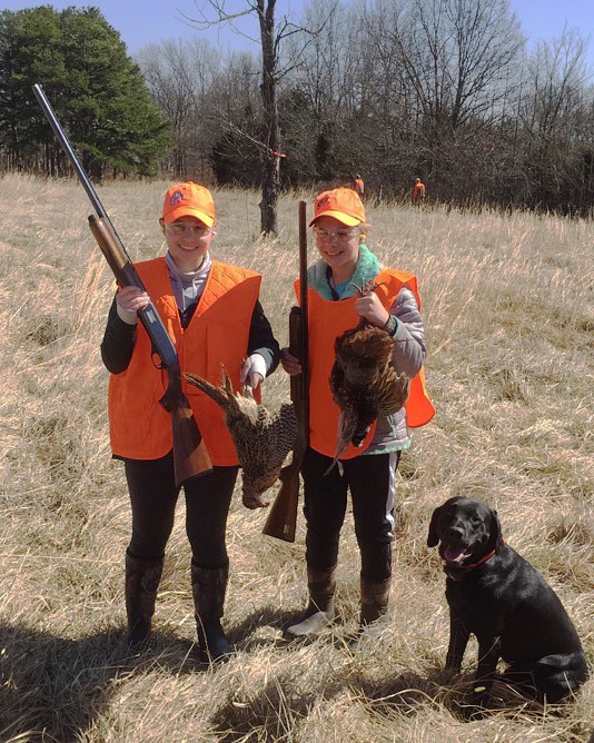 Two women and black lab upland bird hunting