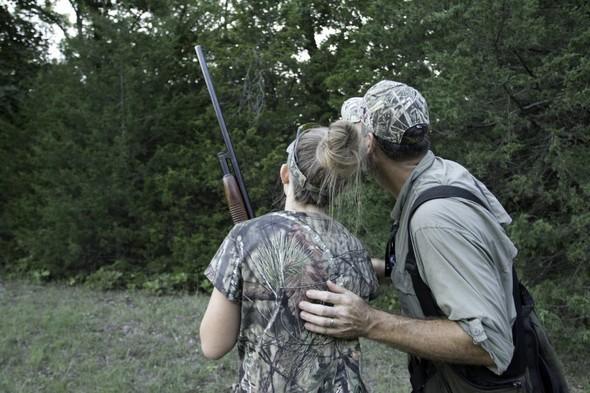 Father and daughter look for squirrels while hunting
