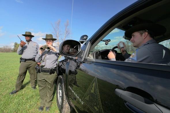 Three conservation agents outside of an MDC truck