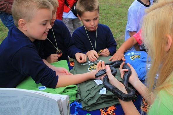 kids touch a black snake at Prairie Day