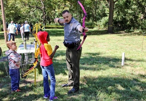 Agent show kids how to shoot a bow and arrow