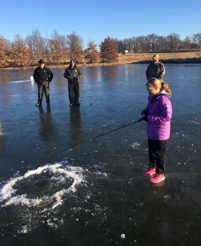 girl icefishing on pond