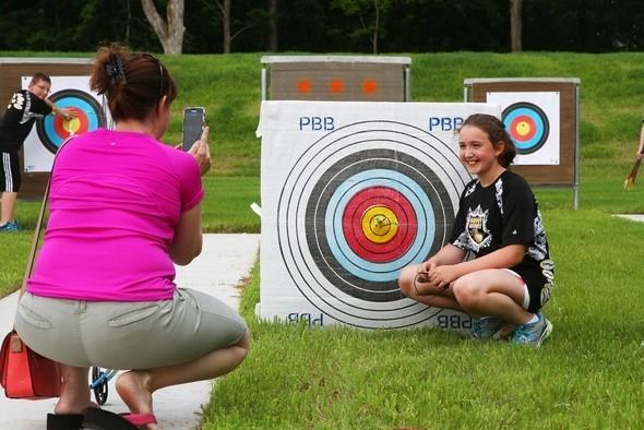 girl poses by archery target