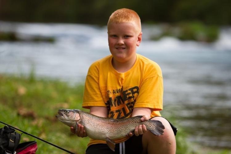 A young angler shows off his trout at Maramec Spring Park.
