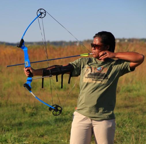 woman shooting blue compound bow