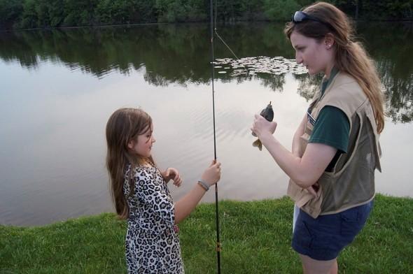 woman teaching girl to fish