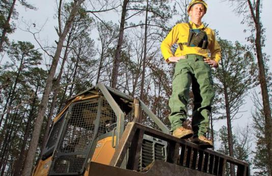 Sam Jewett stands on bulldozer he uses to fight wildfires