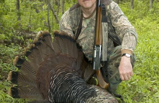A successful turkey hunter with his gobbler.