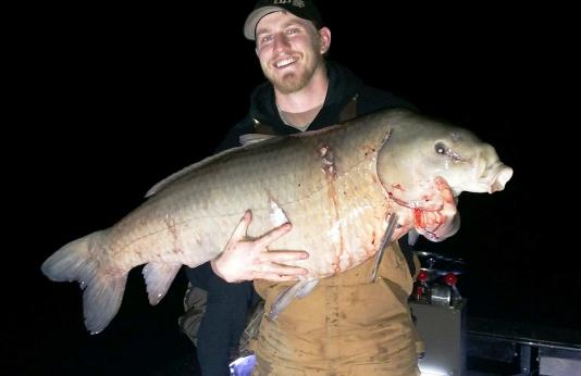 Travis Cardona holds his 74-pound record black buffalo at Duck Creek Conservation Area