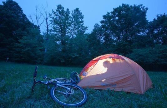 A camper enjoys an evening inside a tent at Davisdale Conservation Area.