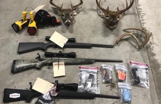 Items seized during the arrest of Harold Piatt, including three firearms and two antlered deer heads.