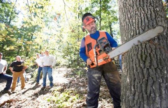 An MDC instructor teaches a class the proper technique for using a chainsaw.