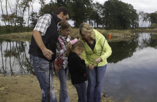 A family baits their fishing pole