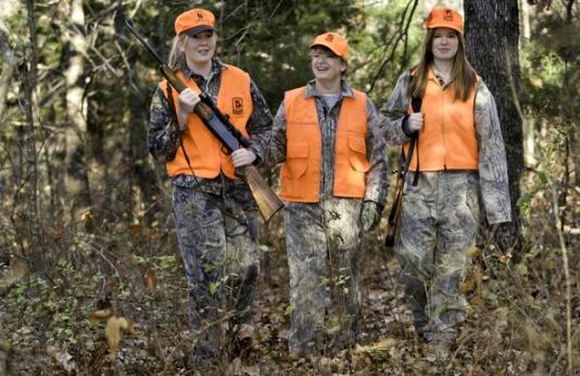 three women deer hunting in woods in camo.