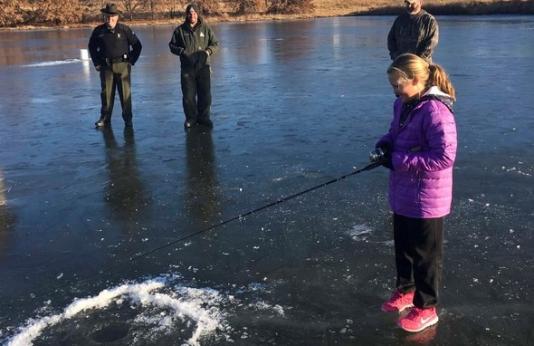 girl ice fishing on pond