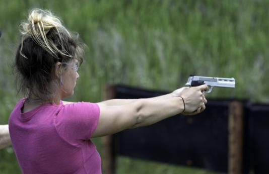 A woman fires a handgun